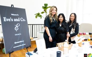 Team members pose by Eve's and Co. signage at a retail pop-up shop event.