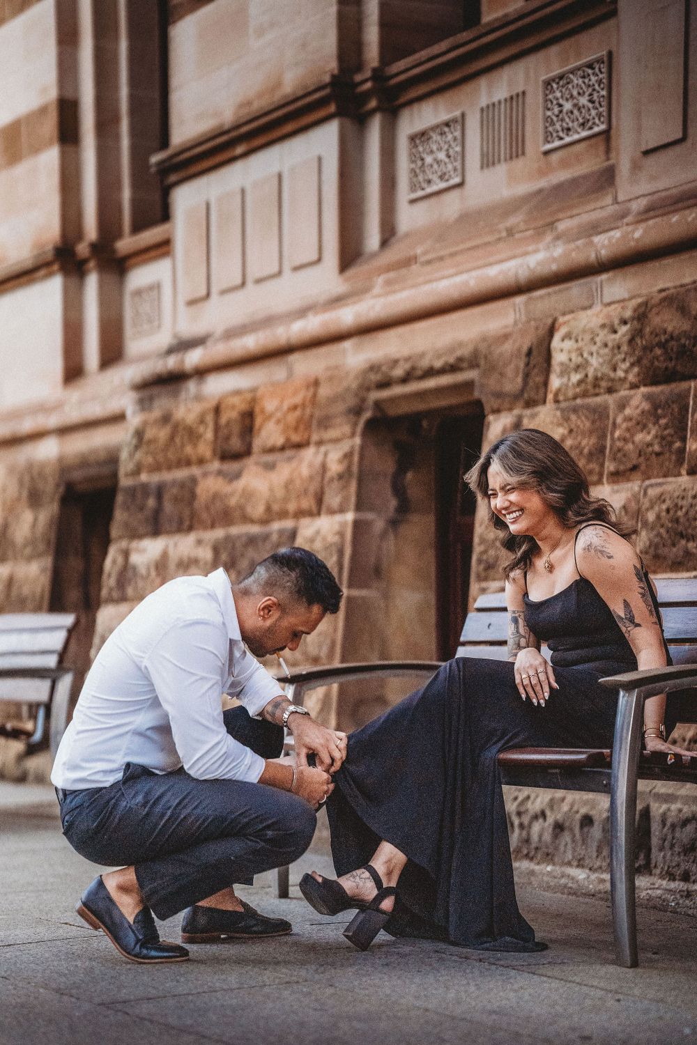 Couple sitting together on stone steps in an intimate pose.