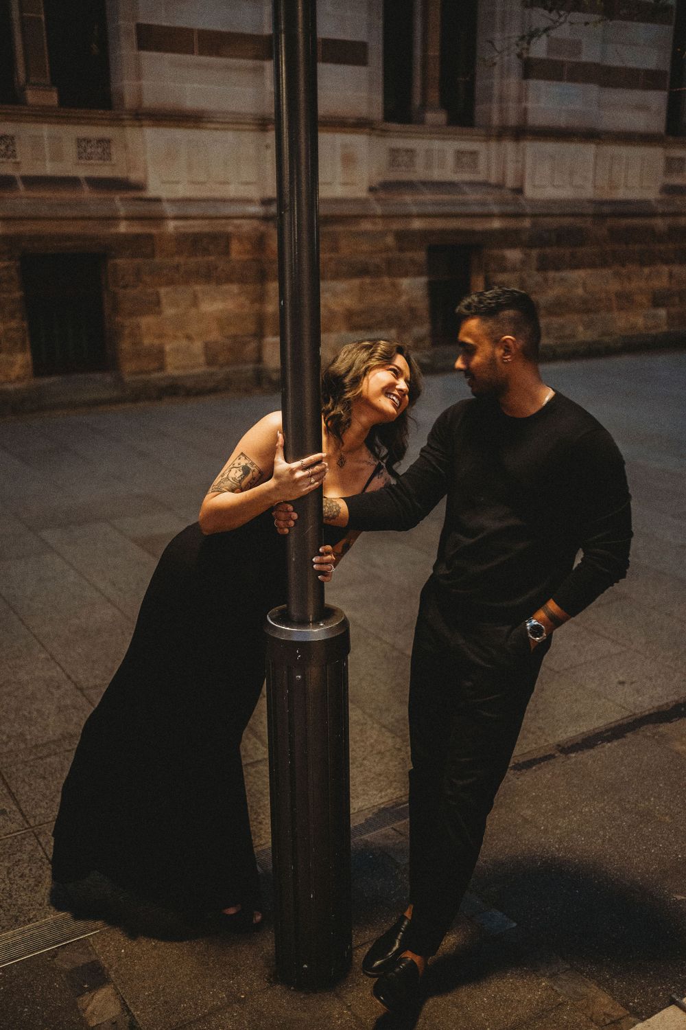 A playful moment captured near a vintage lamp post against historic architecture.