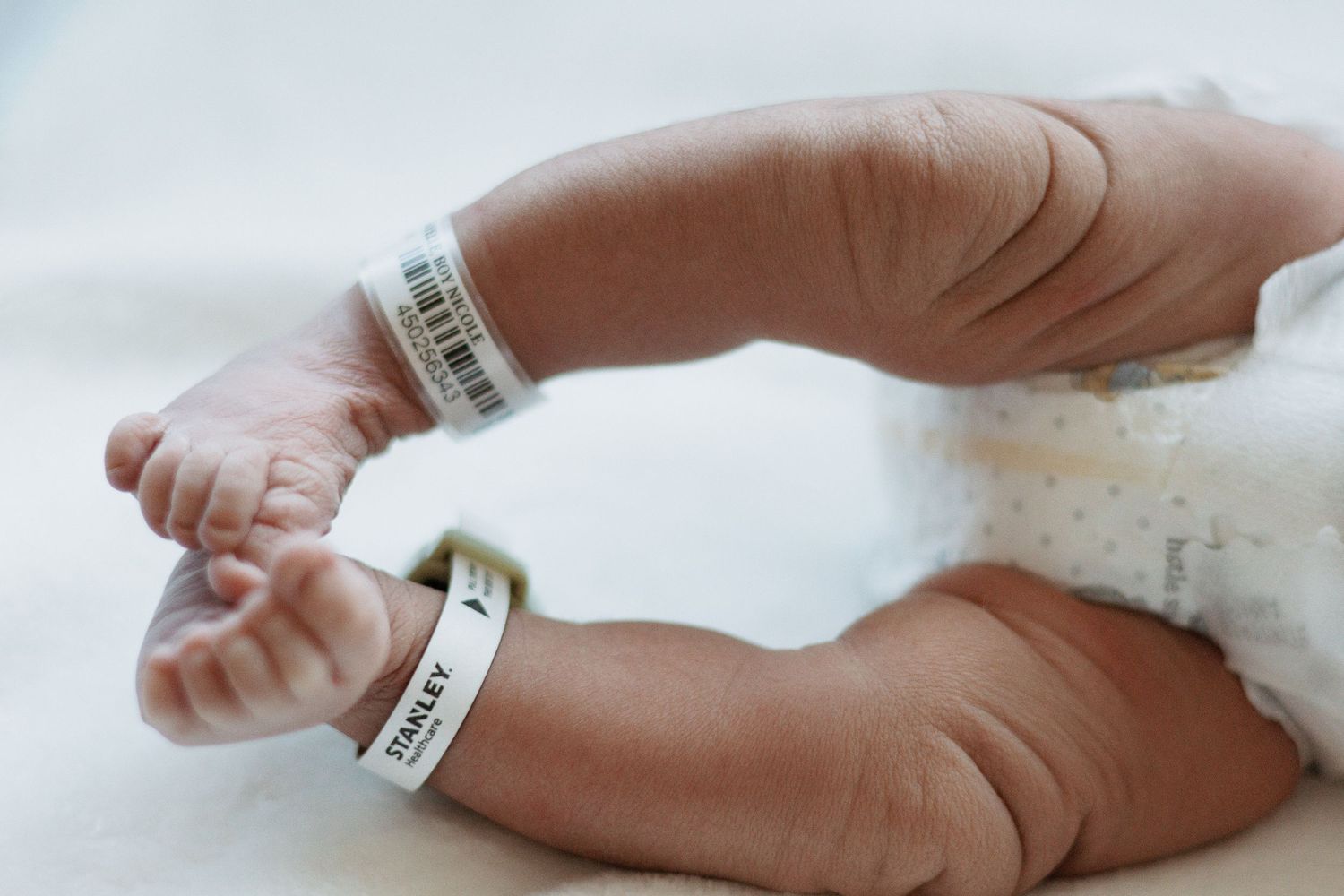 Close-up of newborn baby's feet with hospital identification bands.