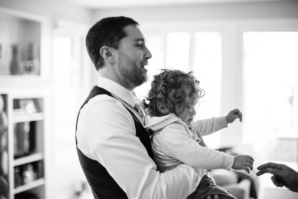 Black and white candid moment of parenting during a relaxed home moment.