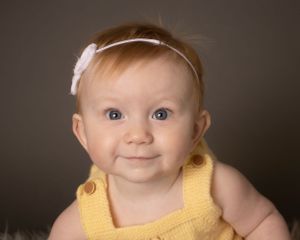 A baby girl makes direct eye contact with the camera
