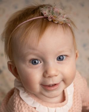 A baby girl smiles at the camera