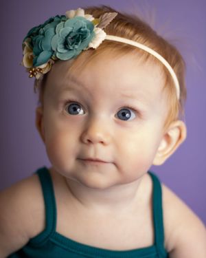 A baby girl looks up and to the left