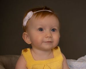 A baby girl looks ahead with a bold expression