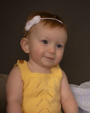 A baby girl tilts her head sweetly