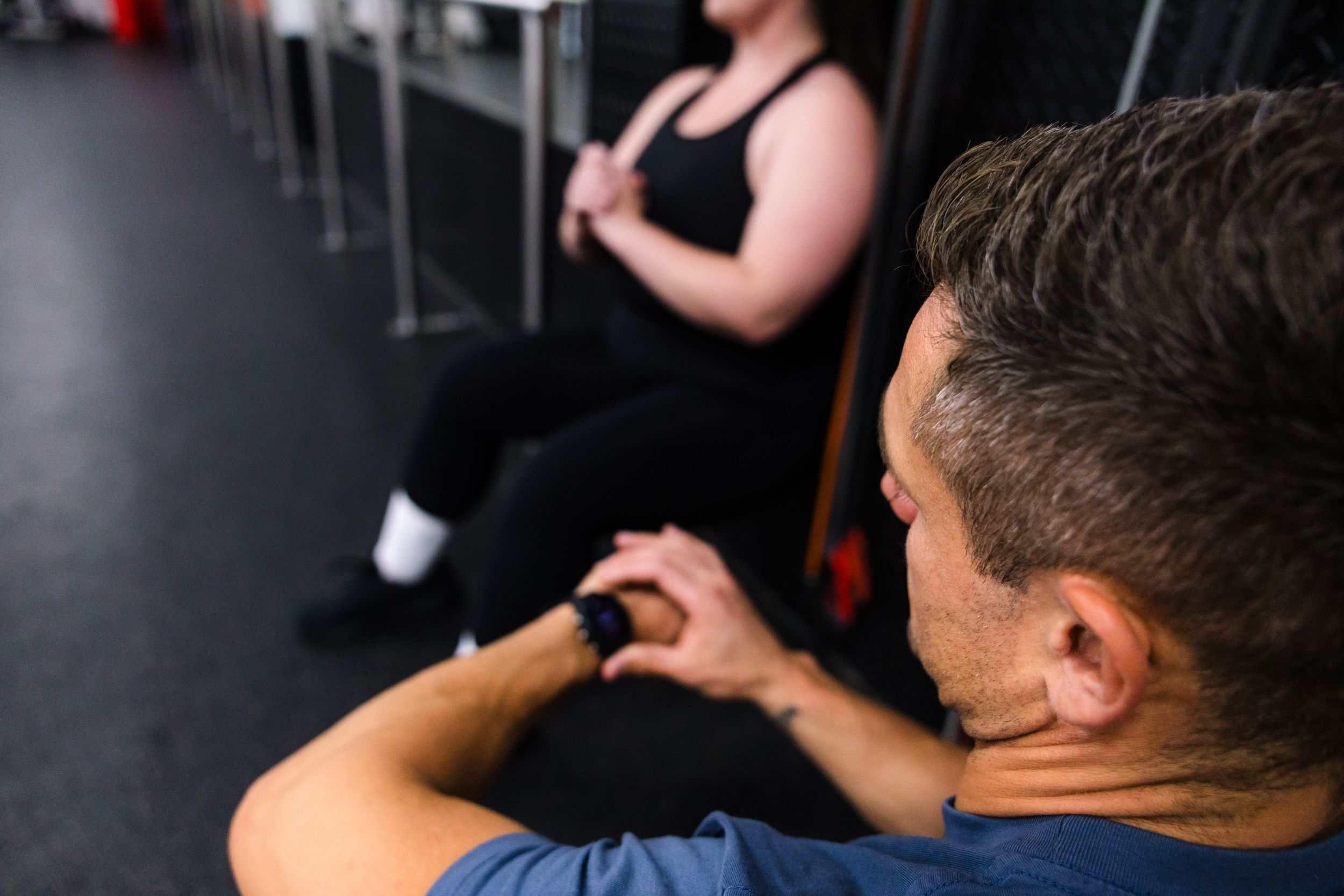 Two people take a break from exercising at a fitness studio.