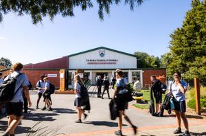 Students in uniform walking outside Darfield High School on a sunny day.