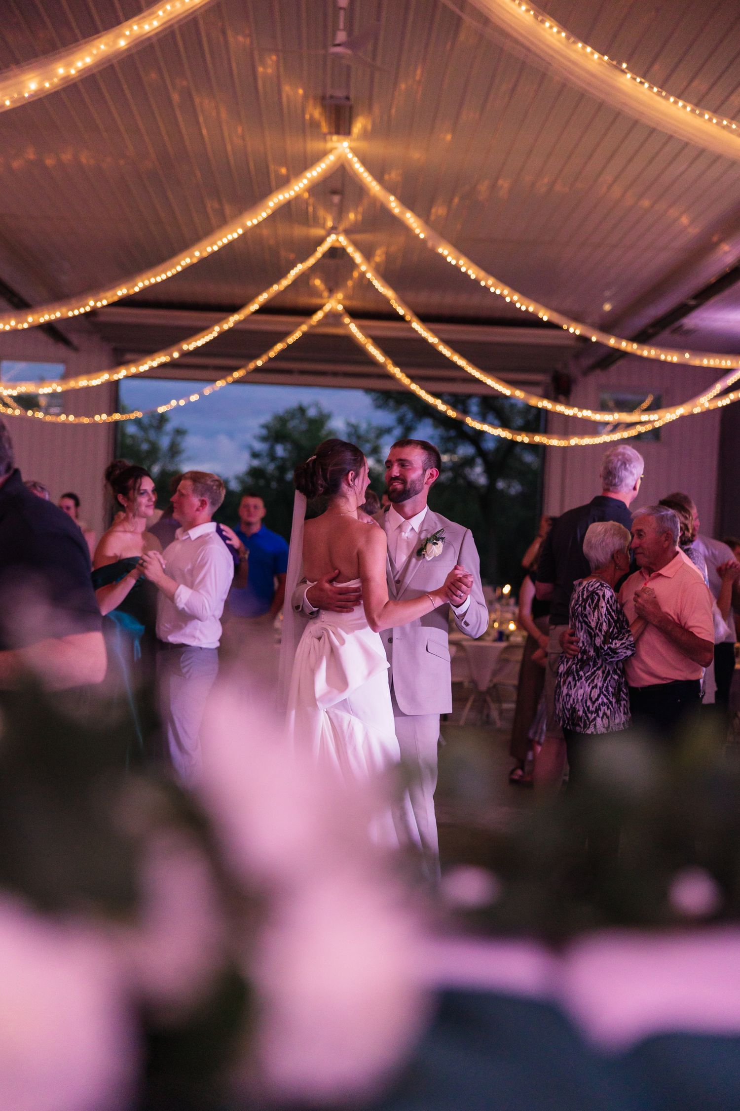Wedding reception dance floor with string lights creating a romantic atmosphere.