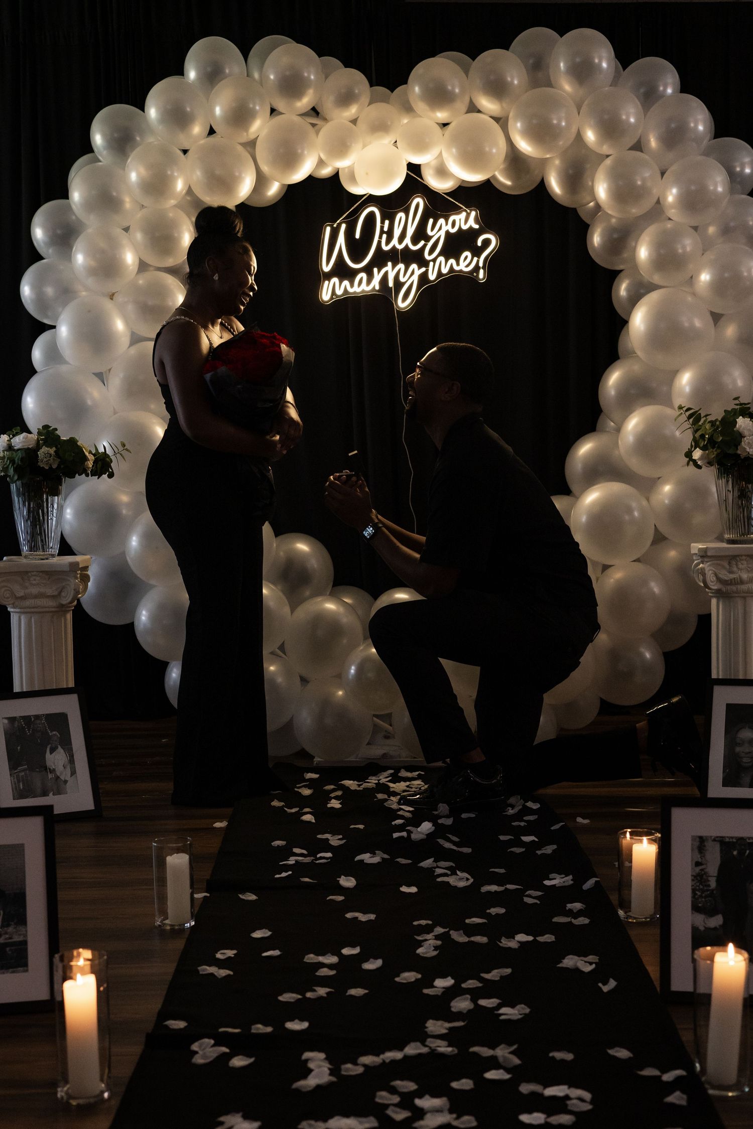 Romantic couple portrait against red background with glowing heart designs.