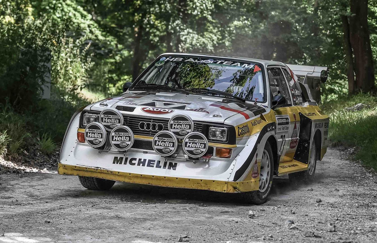 Classic Audi Quattro S1 Group B rally car with distinctive wide body kit on forest rally stage.