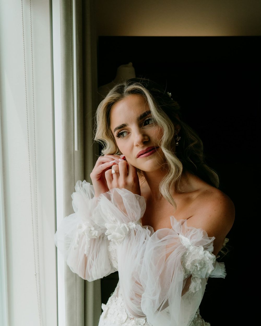 A bridal portrait featuring an ethereal off-shoulder gown with delicate tulle details.