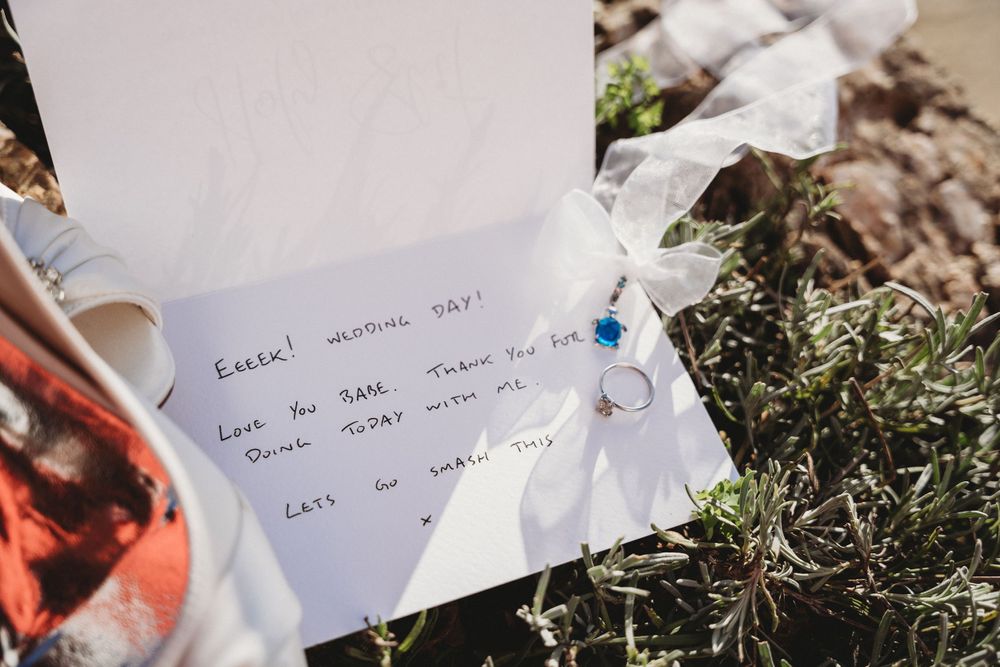 Close-up of wedding stationery with handwritten notes against natural backdrop.
