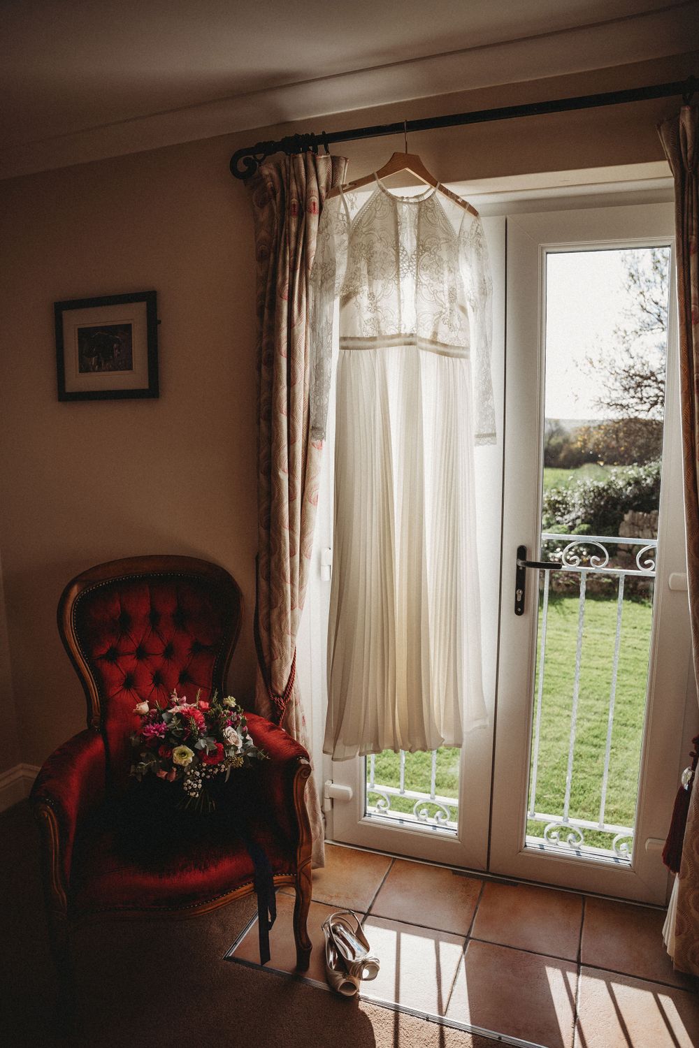 Elegant room interior with red velvet chair and sheer curtains by large windows.