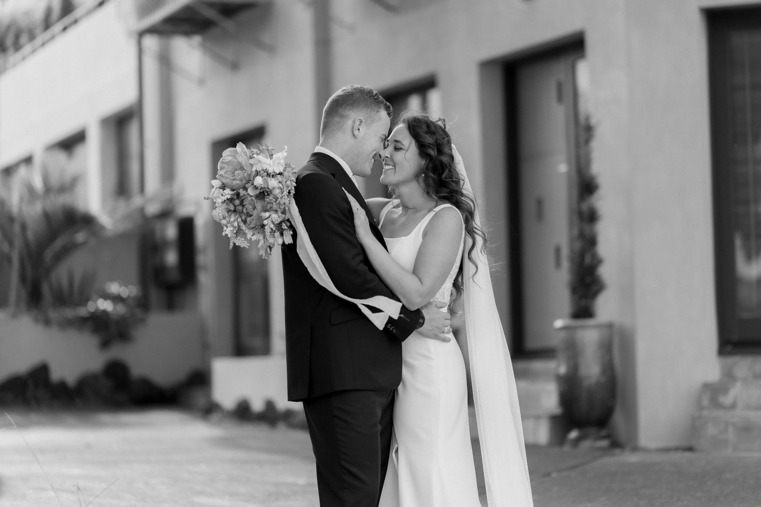 Black and white wedding photography sequence showing romantic moments against urban architecture.