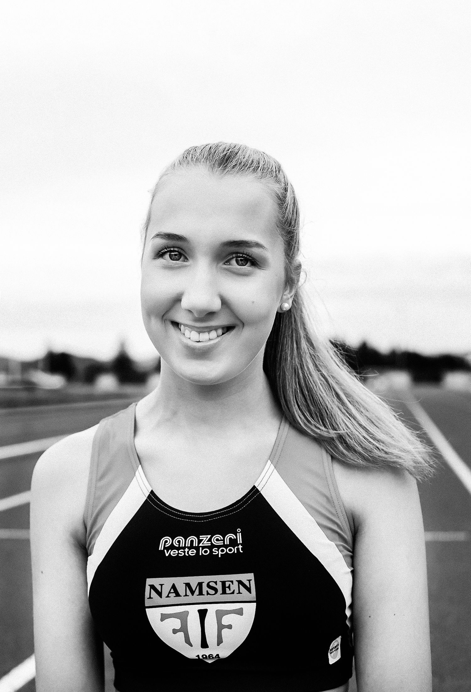 A black and white athletic portrait of a runner wearing a Namsen ALF sports jersey.