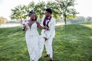 Happy newlyweds share a joyful moment together on sunny lawn.