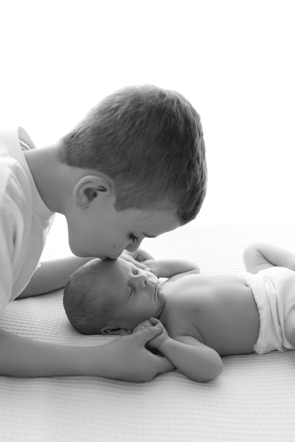 Tender black and white portrait of siblings sharing intimate moment.