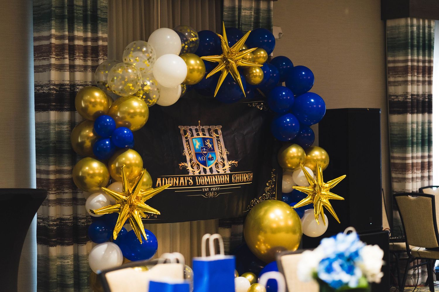 Party decorations featuring blue and gold balloon arch with star accents.