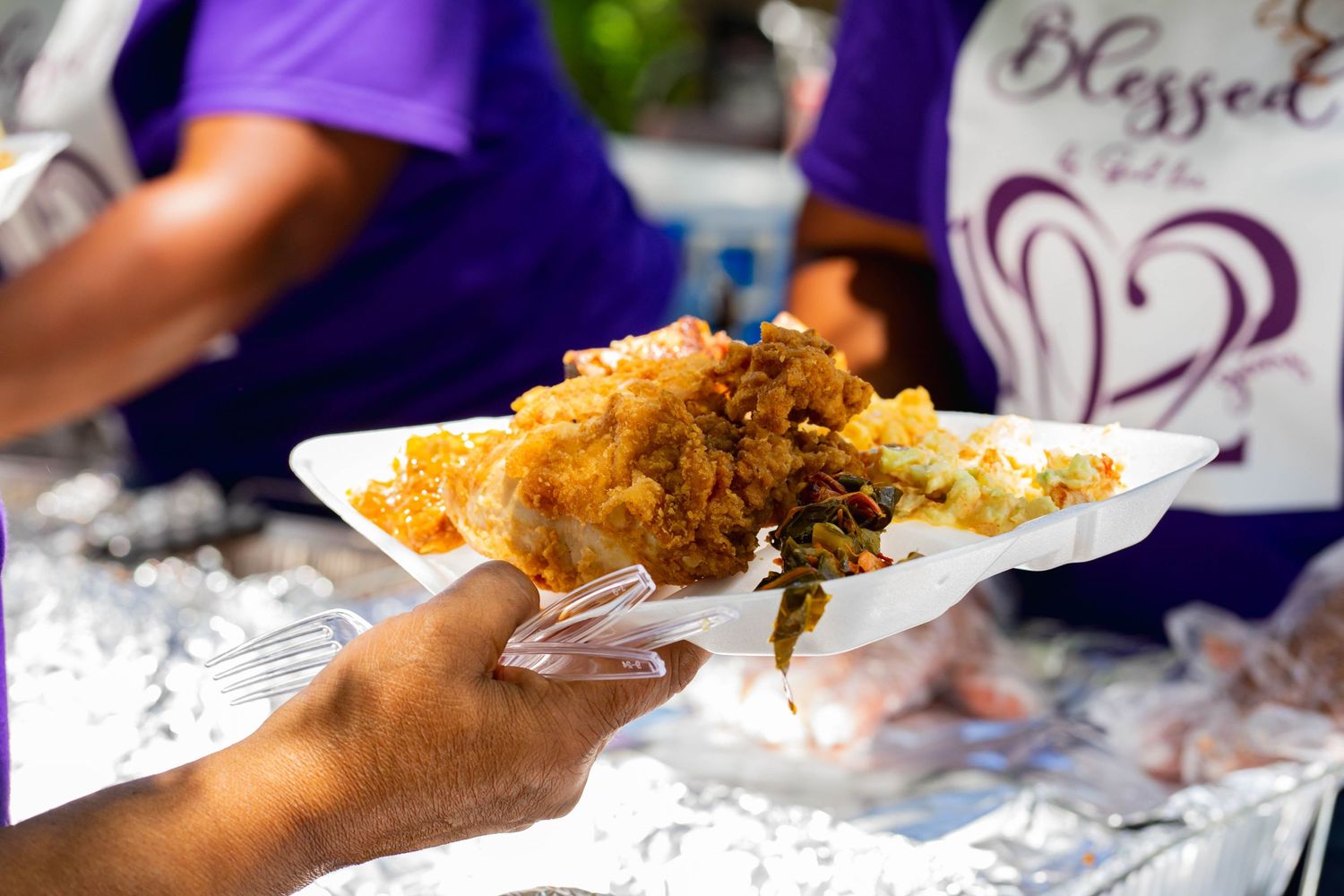 A plate of golden fried food being served at an outdoor event.