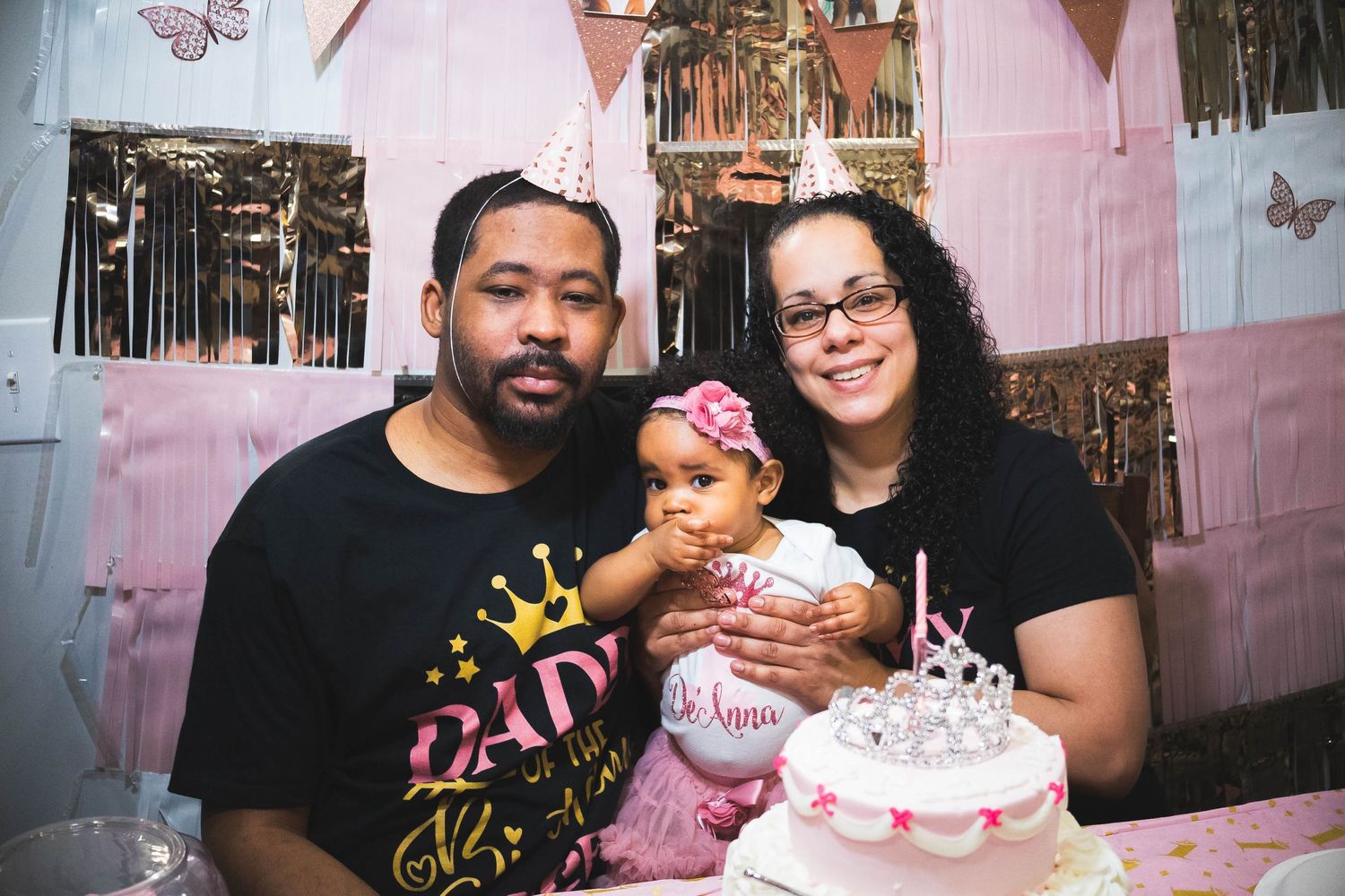 A celebration with a pink birthday cake and decorations at a family party.