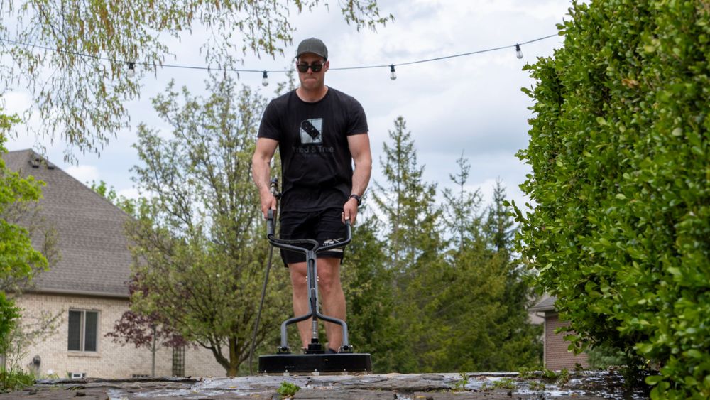 A man with a power washer cleaning concrete
