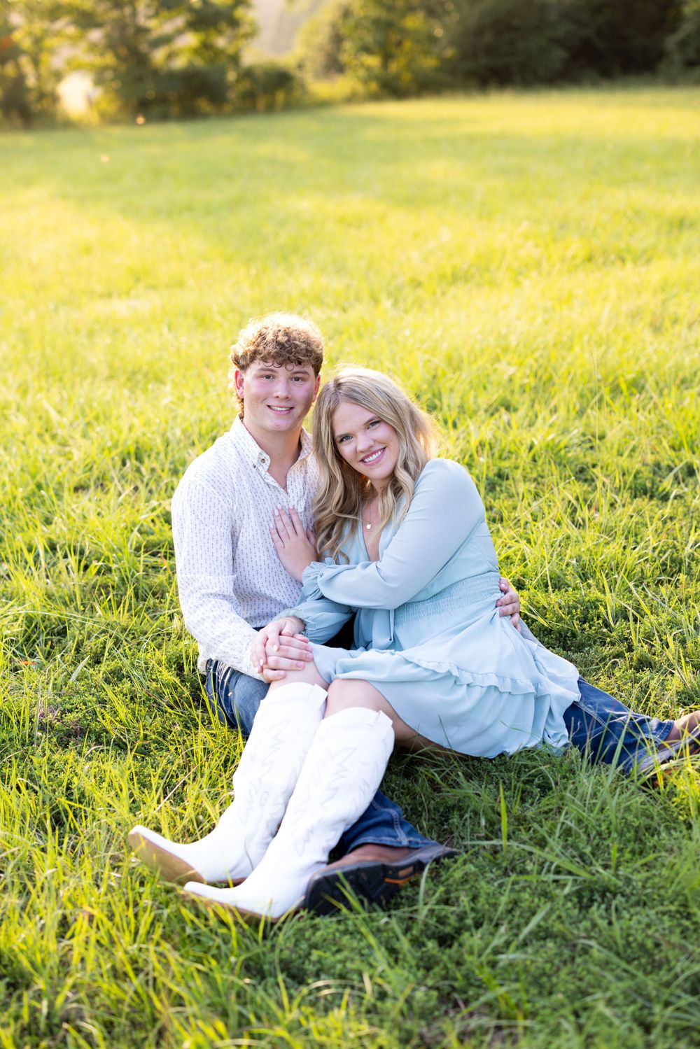 Two people relaxing together on grass during a sunny afternoon.