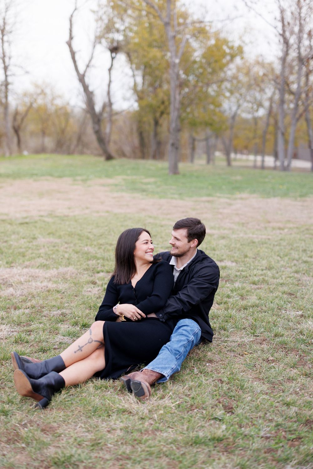 Couple laying down and laughing together on autumn grass.