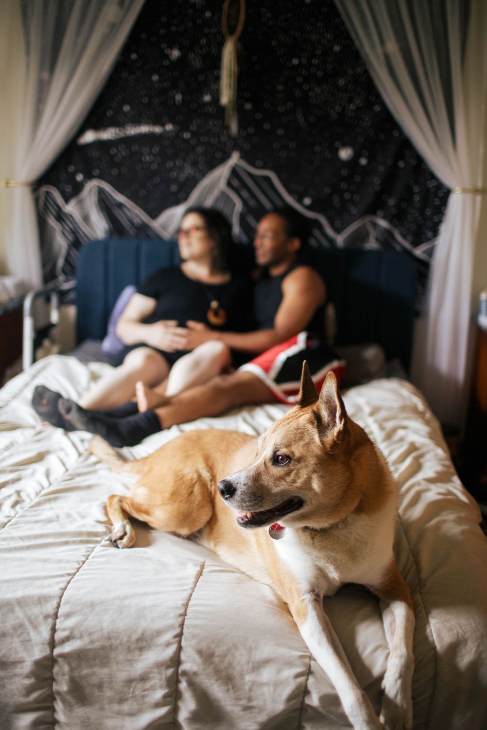 Everett maternity photos: Two to-be parents lay on their bed at a photo shoot at home in Everett WA