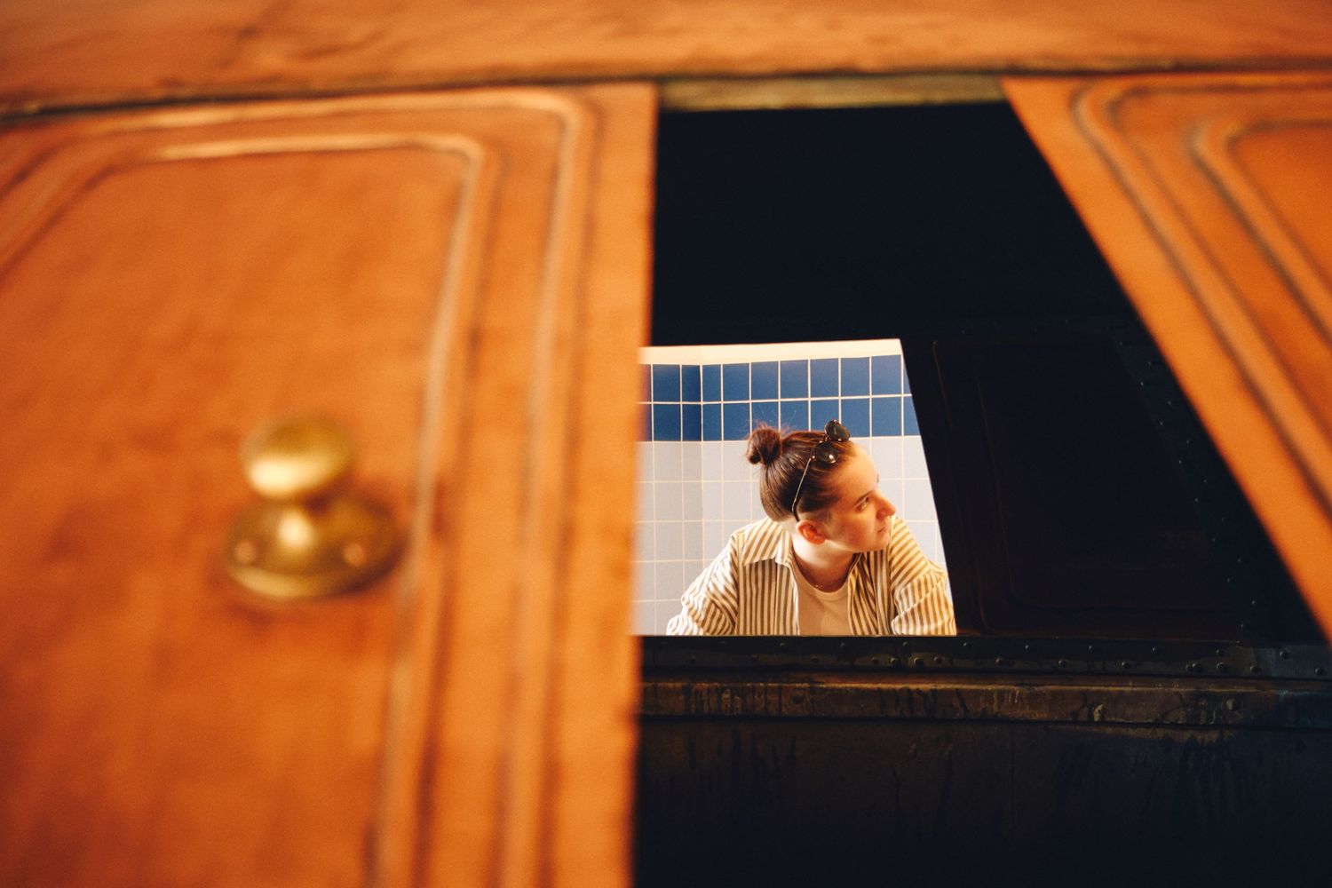 View through a wooden cabinet window showing a glimpse inside.