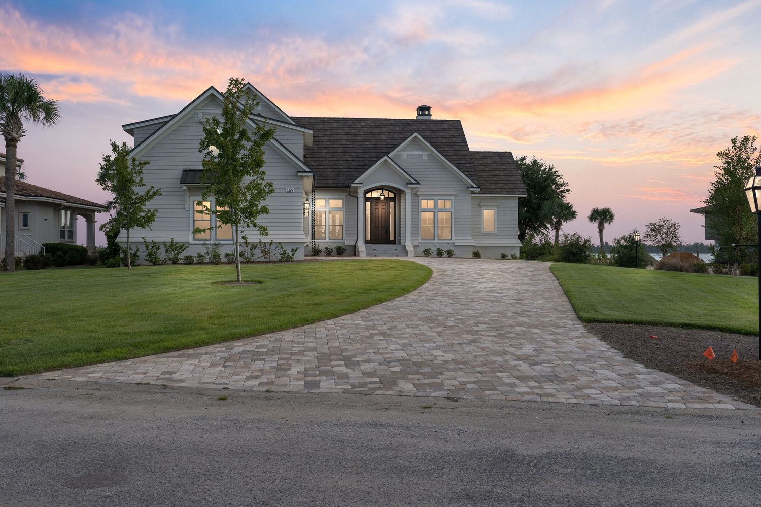Brown two story home with long driveway and a beautiful lawn.