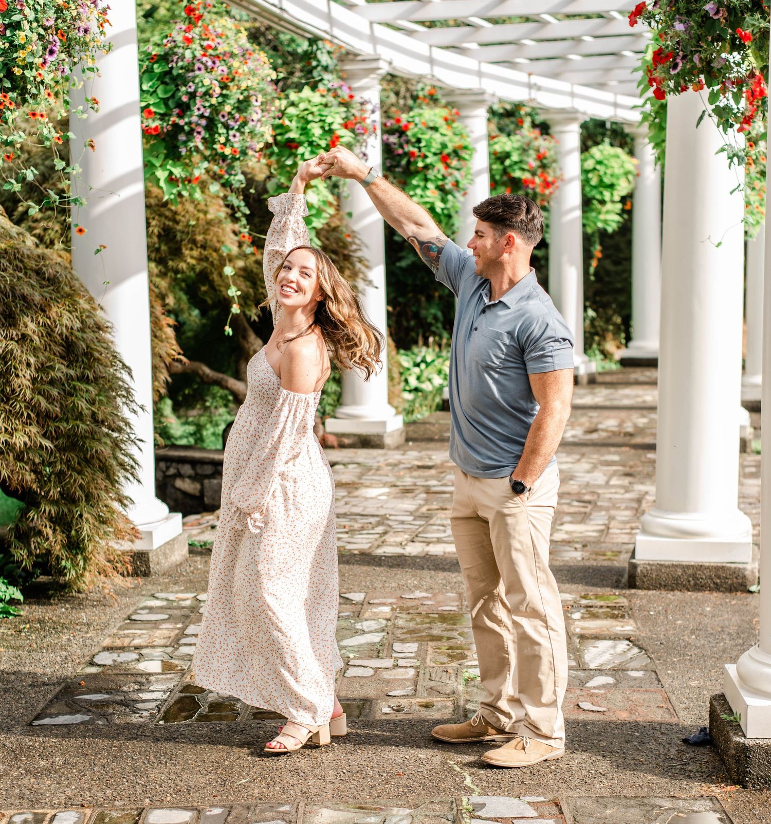 Candid maternity photos captured under a garden pergola with stone pathway.