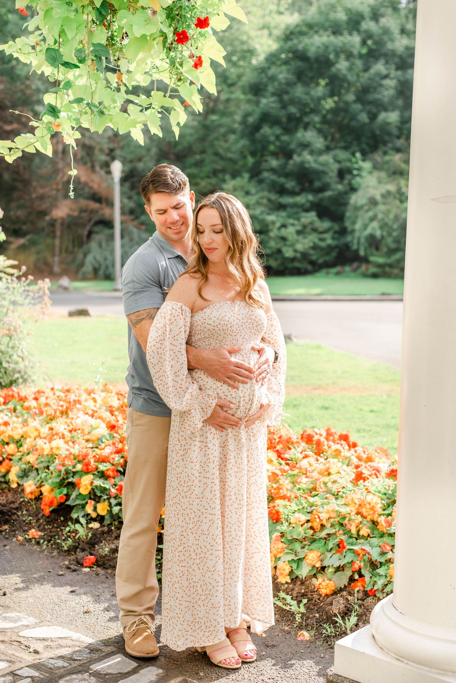 Romantic garden portrait with orange flowers and white architectural column in background.