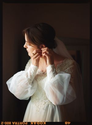 A close-up of delicate lace wedding dress details with statement puff sleeves.