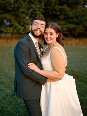 Joyful wedding portrait of couple embracing outdoors in formal attire.