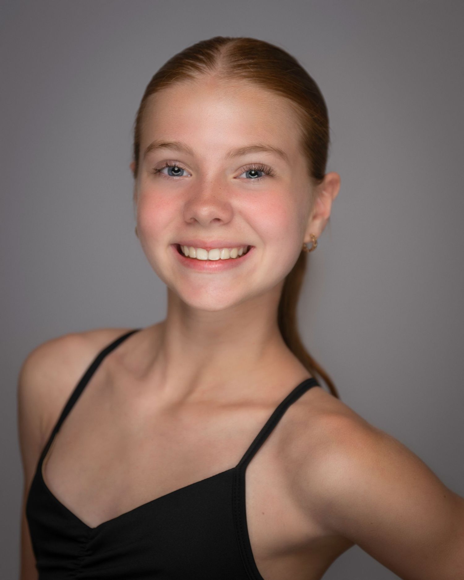 Studio headshot of performer in black dance wear with sleek ponytail against neutral backdrop.
Pittsburgh Dance Photographer