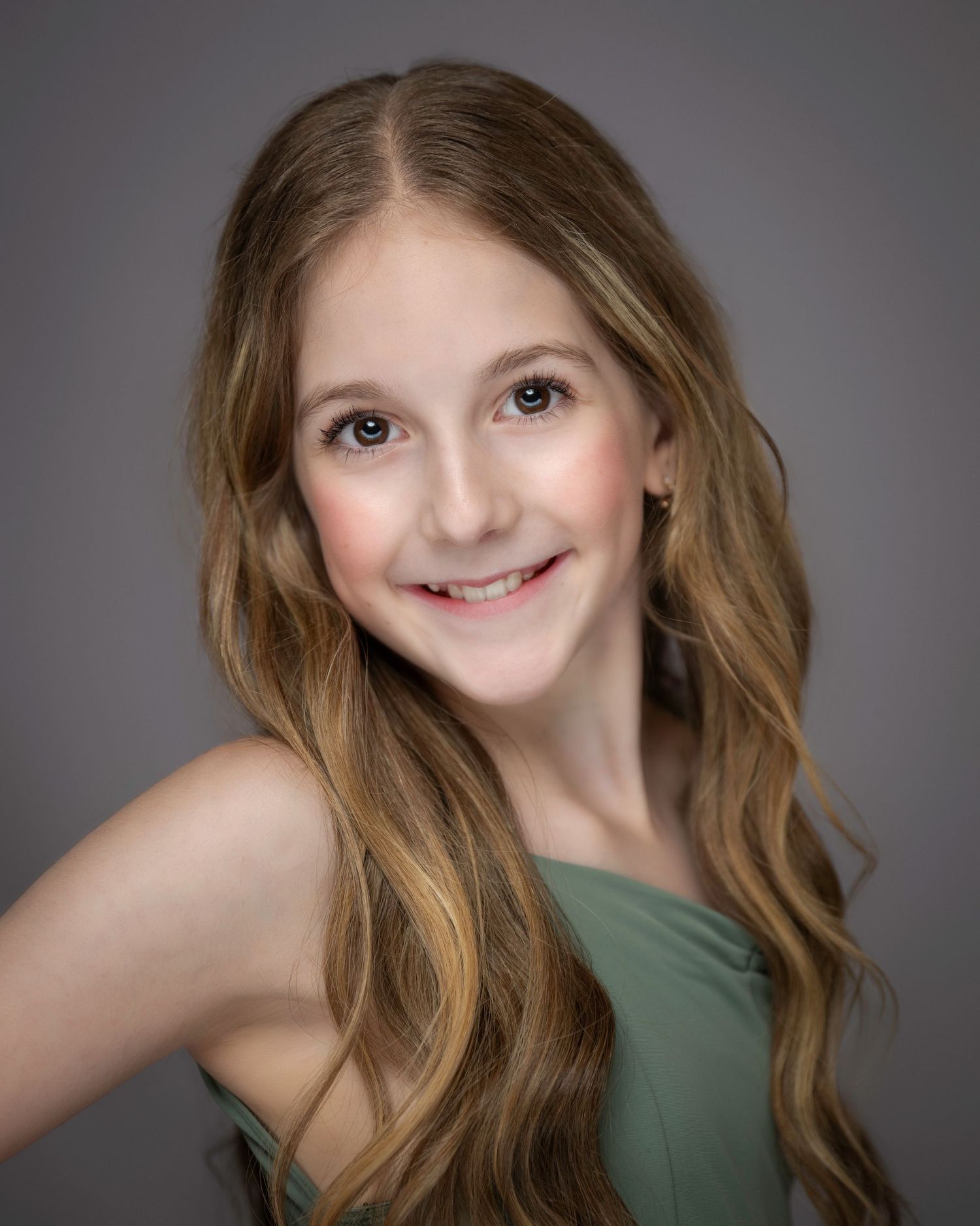 Dance portrait showing performer in olive top with wavy caramel hair against gray backdrop.
Pittsburgh Dance Photographer