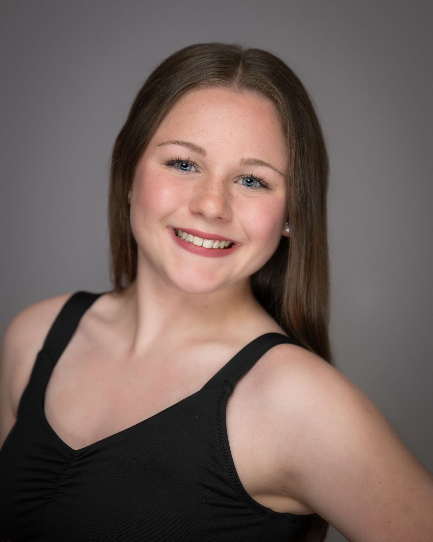Portrait of dancer in black tank top with straight brown hair and warm smile.
Pittsburgh Dance Photographer