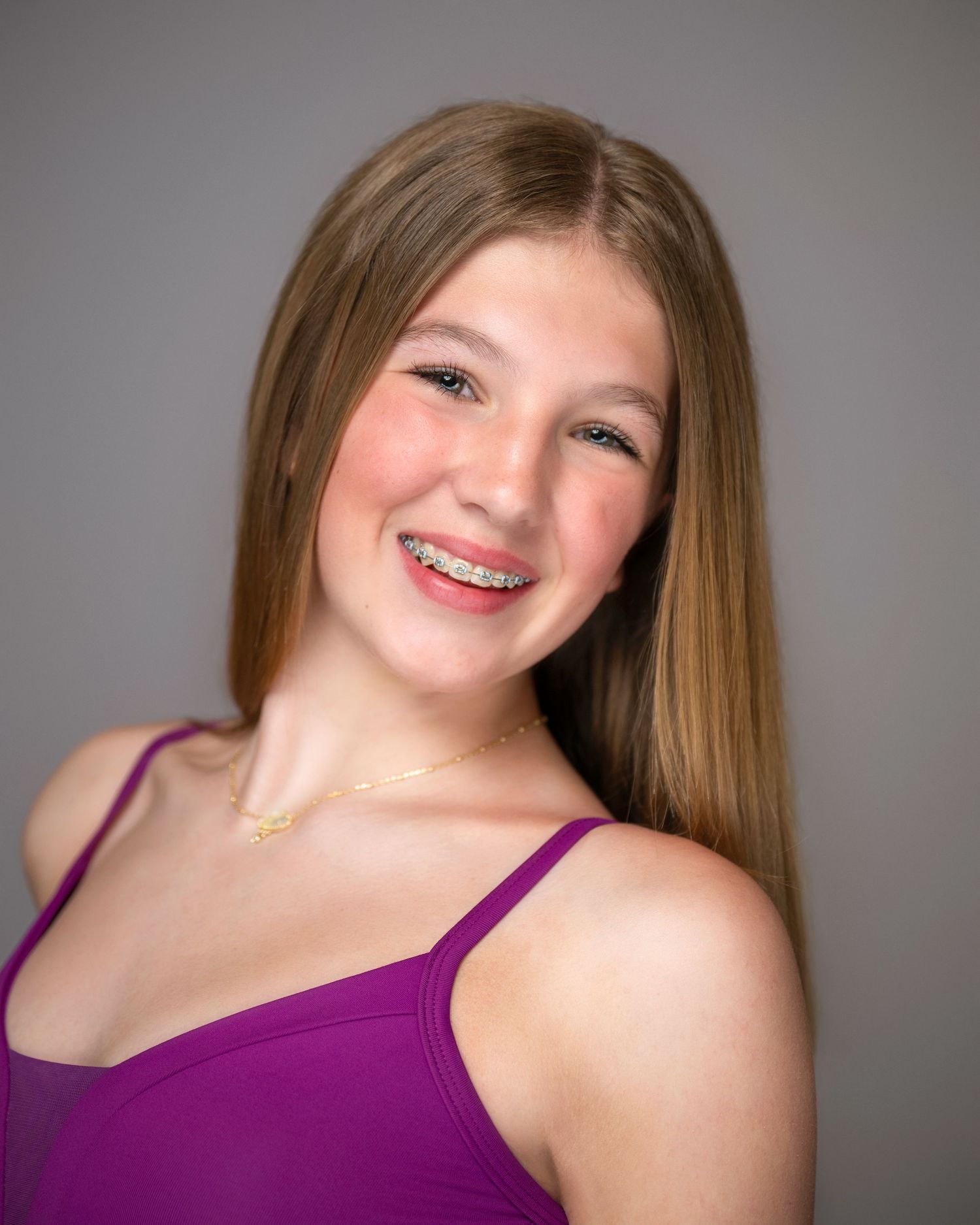 Performance headshot in purple dance wear with straight hair and cheerful expression.
Pittsburgh Dance Photographer