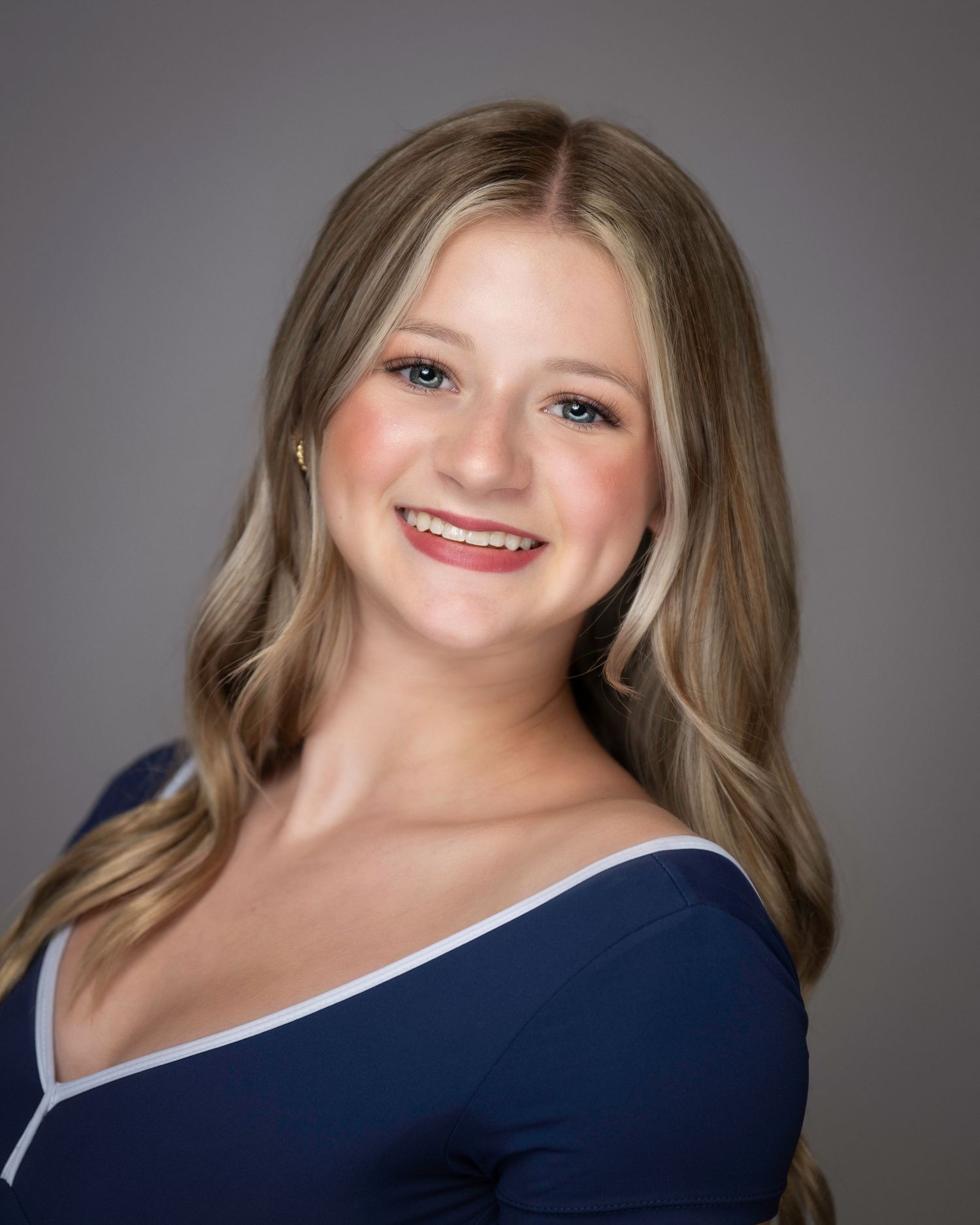 Professional portrait in navy blue top with wavy hair and natural makeup against gray backdrop.
Pittsburgh Dance Photographer