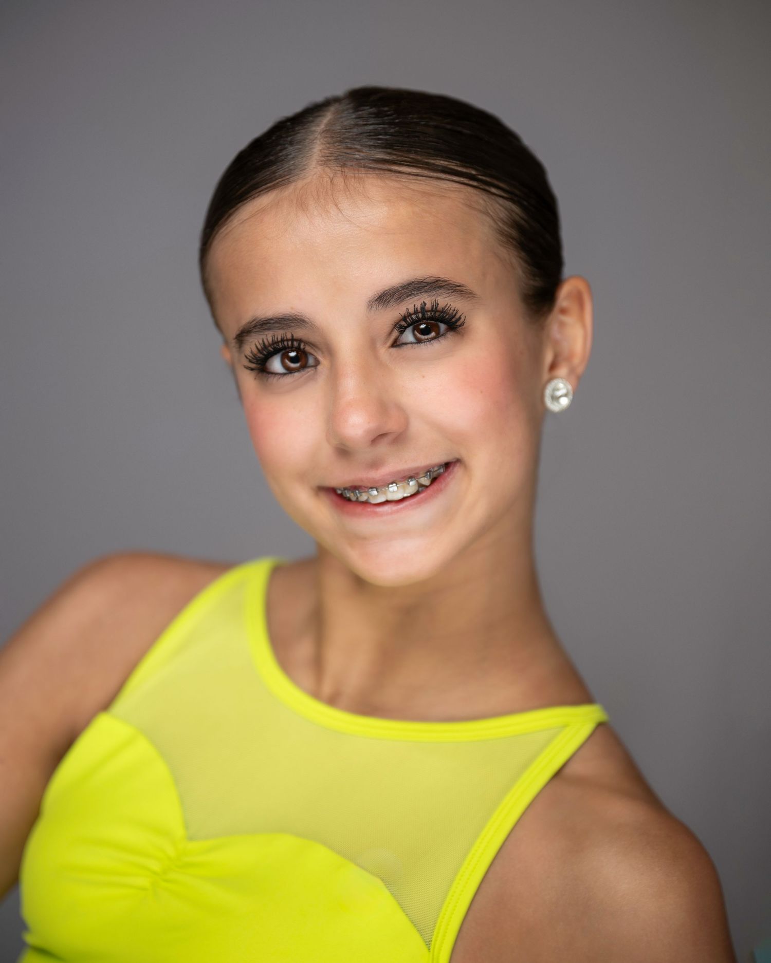 Dance portrait in bright yellow top with sleek updo and sparkly earrings. Pittsburgh Dance Photographer