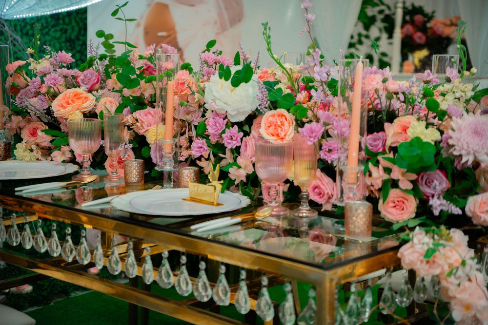 Elegant table setting with pink roses and candles on a gold mirrored table.