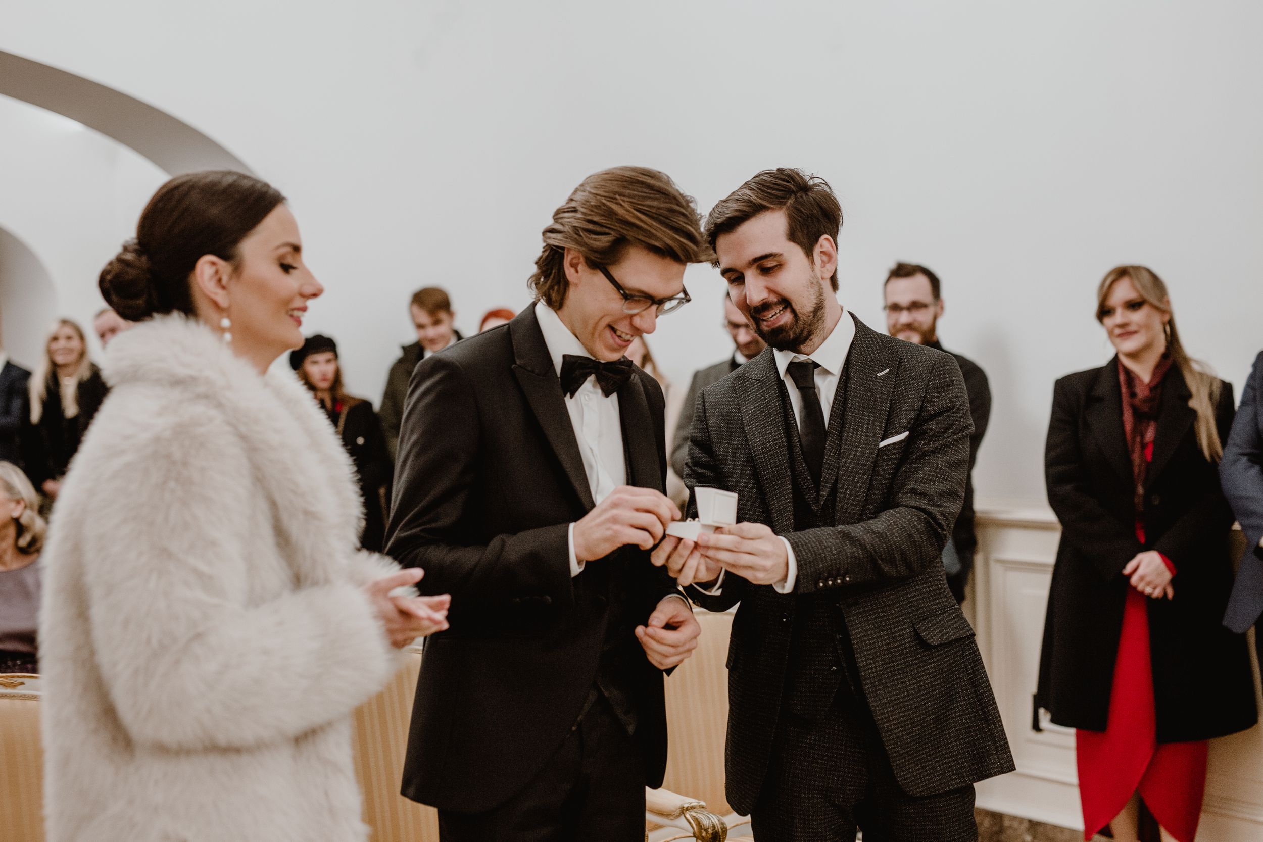 Bride and groom exchanging wedding rings at the Registrar's Office in Zagreb, surrounded by family and friends.