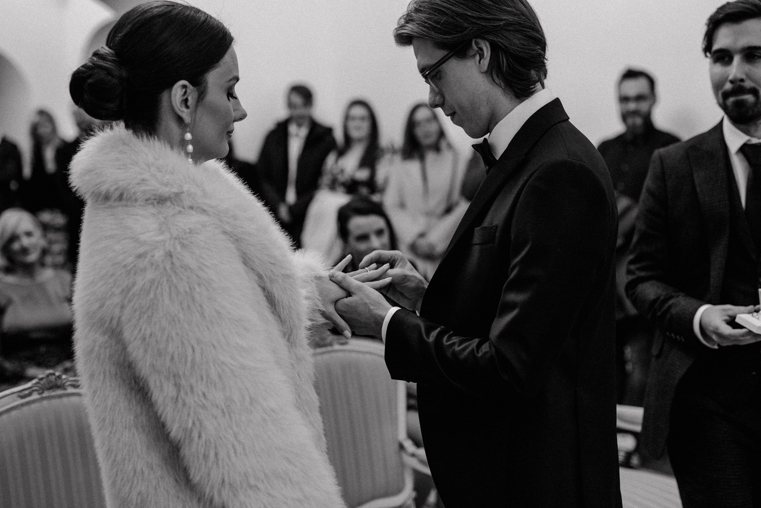 Groom gently slipping the wedding ring onto the bride's finger, capturing a tender moment in Zagreb.