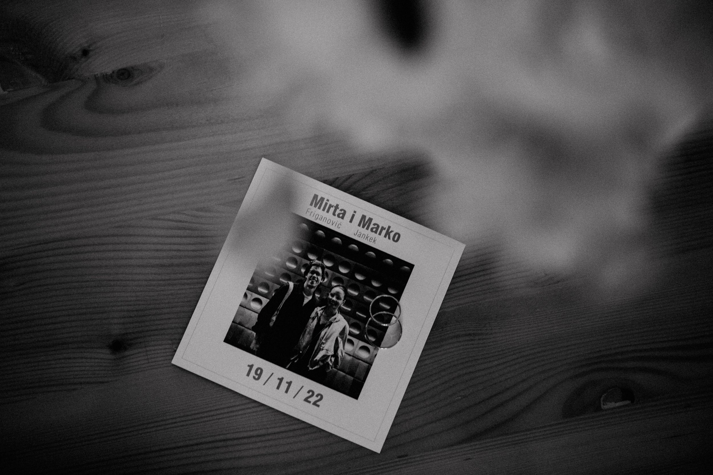 Black and white polaroid photo on a wooden surface with soft focus.