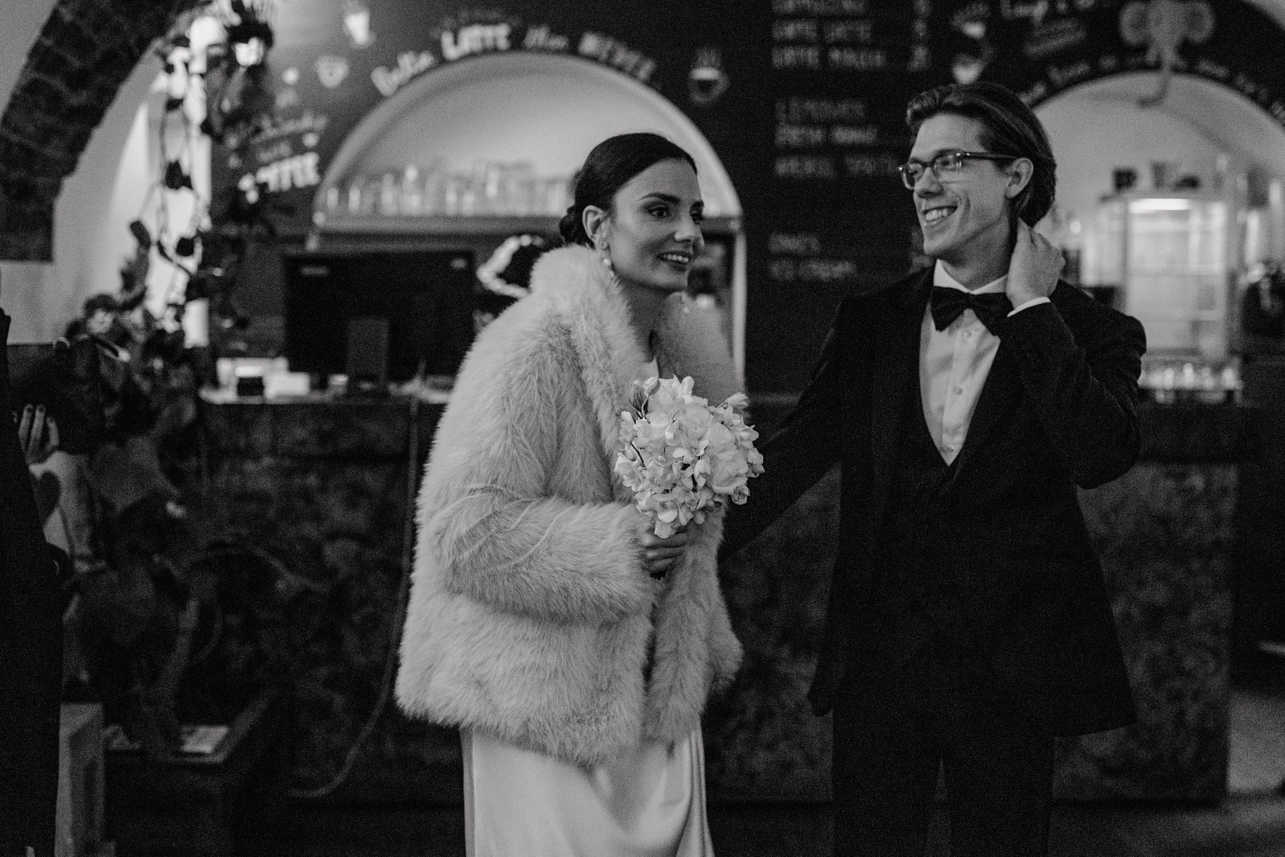 Bride and groom entering a charming, quaint cafe with a warm and inviting atmosphere before their wedding ceremony.