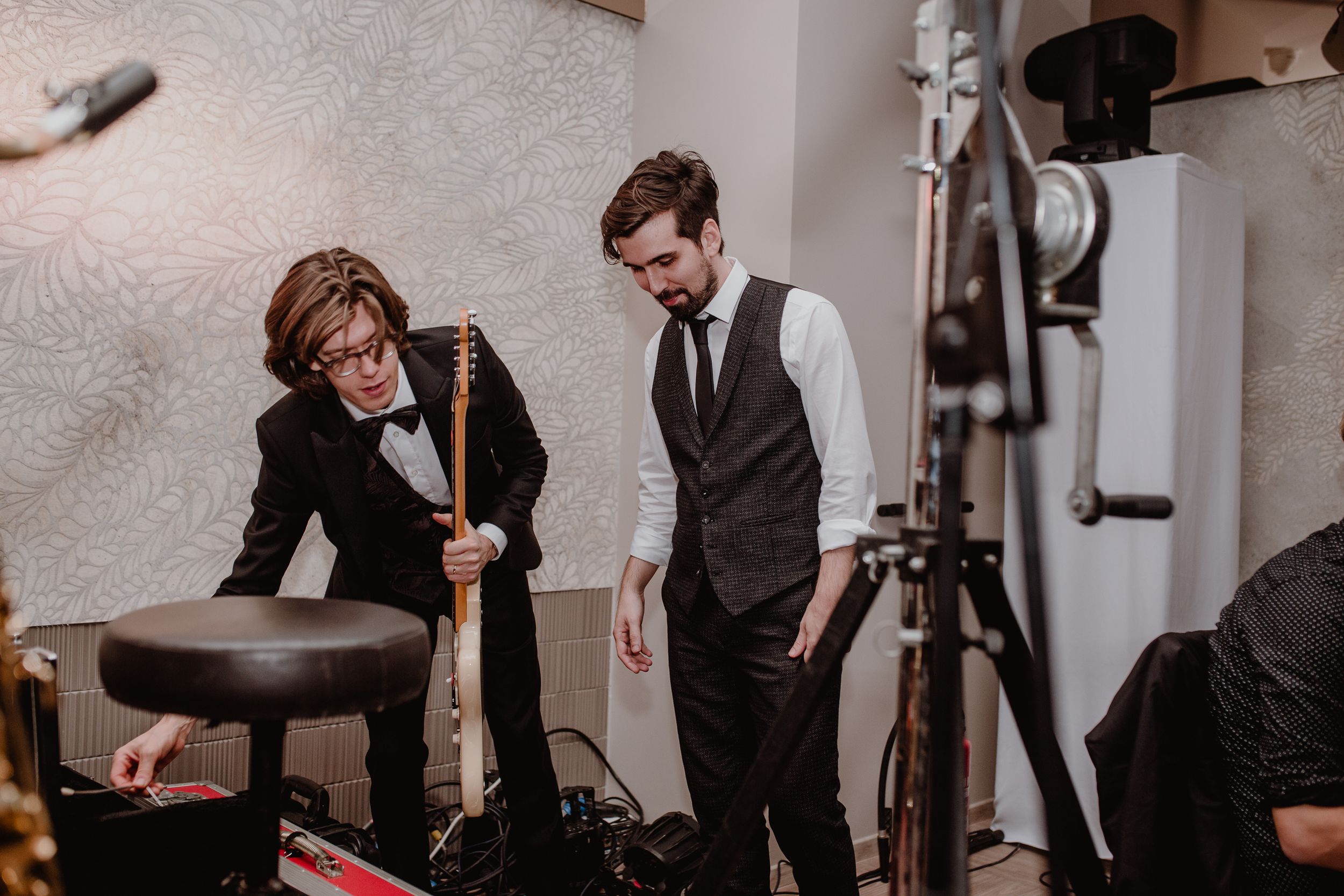 Groom and groomsman getting ready to perform their song with the band during the wedding party.