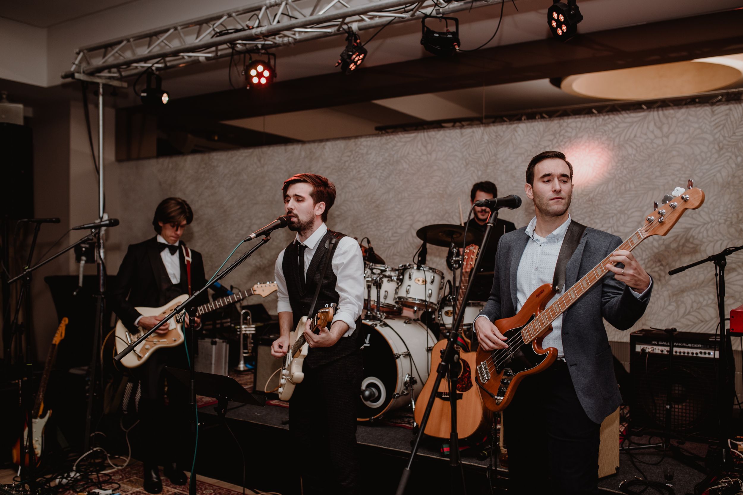 The groom and best man passionately playing with their band during the wedding party, creating an unforgetable night.