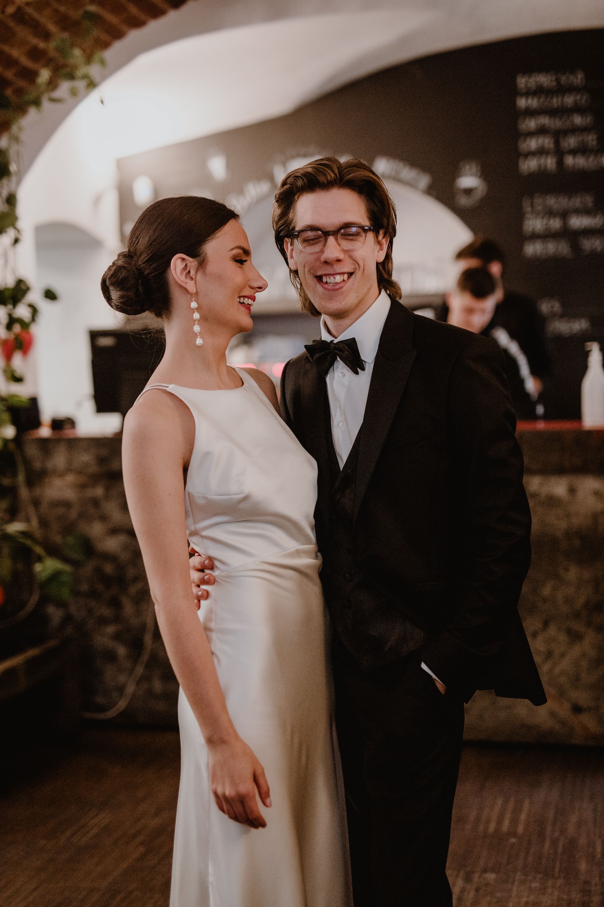 Newlyweds walking hand in hand into a cute, cozy cafe, adding a touch of charm to their pre-ceremony moments