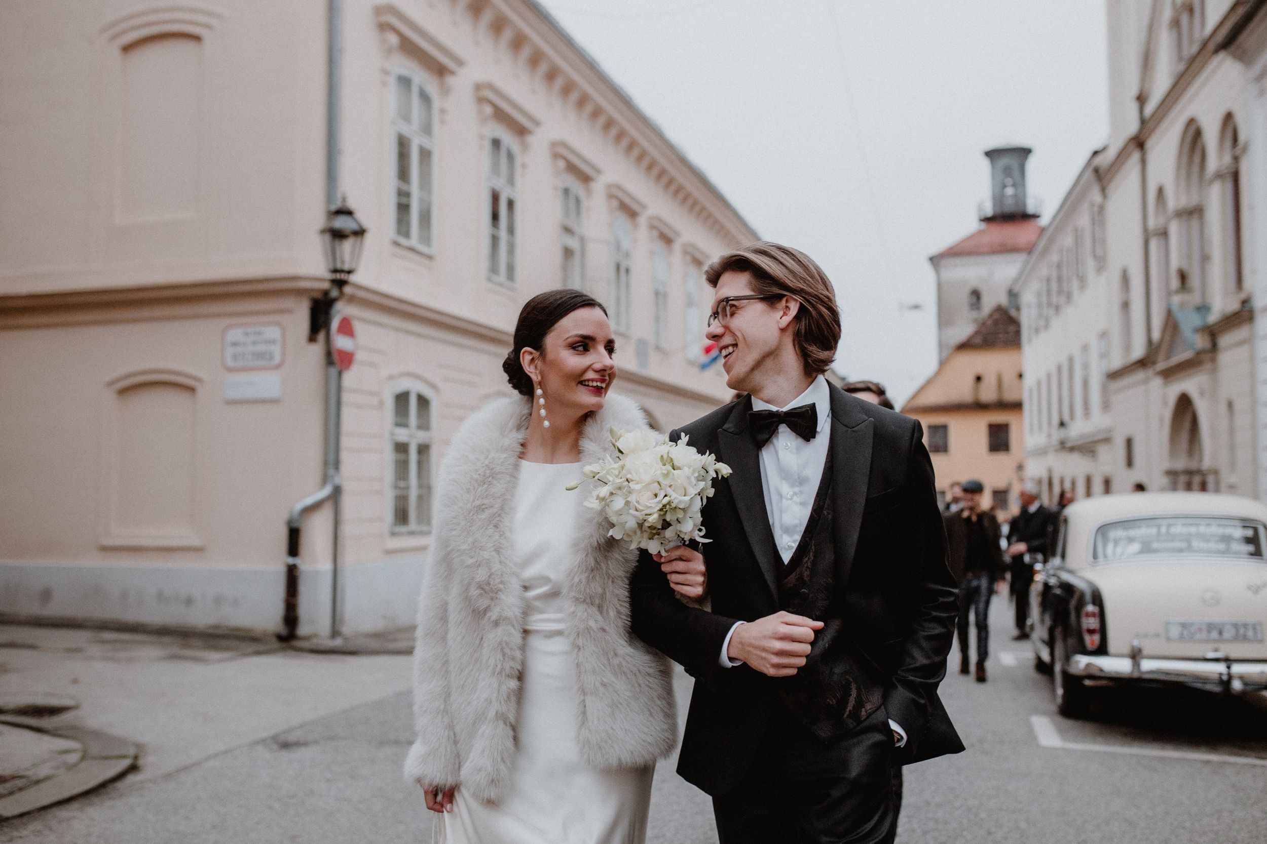 The bride and groom stroll together towards the marital office in Upper Town, Zagreb, with the picturesque backdrop.